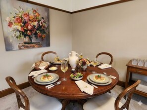 Een eettafel gedekt voor vier personen, met borden, glazen en bestek.