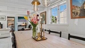 Ein Essbereich mit Holztisch, Kerzen und einem Blumenstrauß.
