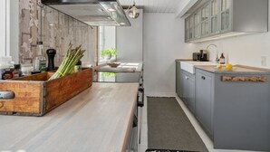 Eine moderne Küche mit einer Holzausziehtheke, einem eingebauten Herd und einem großen Fenster.