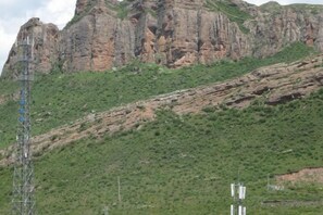 Een bergachtig landschap met rotsachtige kliffen en schaarse begroeiing.