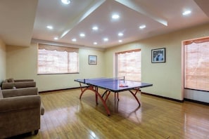 A room with a ping pong table, cushioned seating, and large windows with blinds. - GOLD RIVER-SIDE HOTEL WUZHEN (Tongxiang)