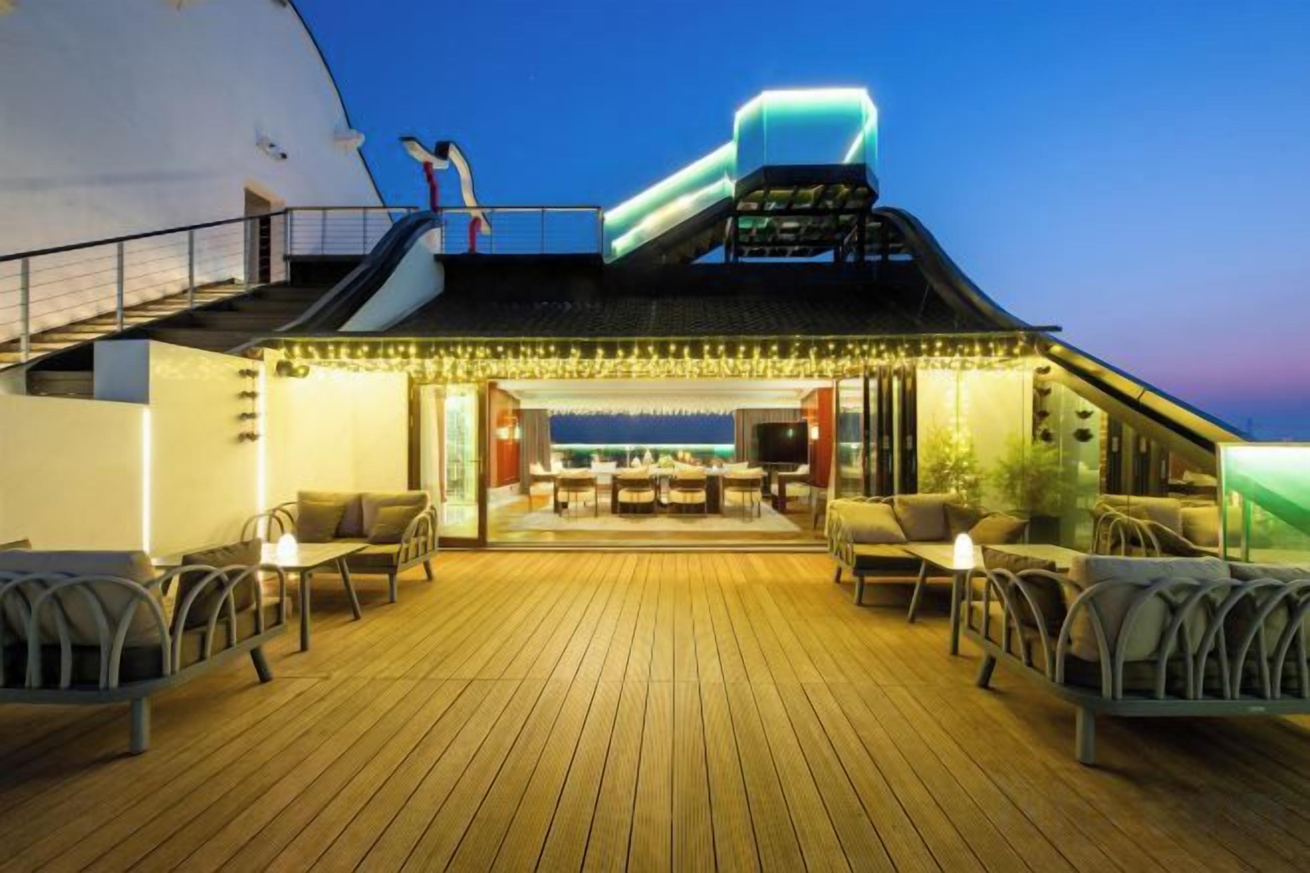 A deck with outdoor seating and a covered area with a table and chairs.