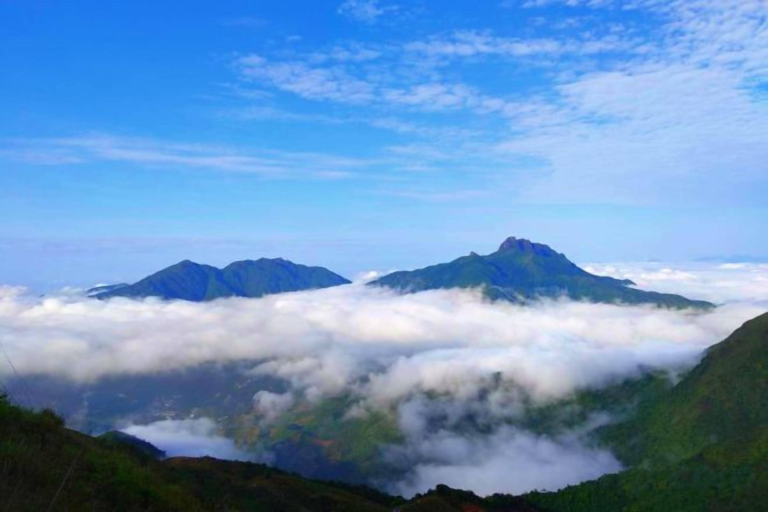 A mountainous landscape with two prominent peaks and a valley below.