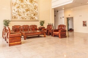 A conference room with a long table and multiple chairs, a large abstract painting on the wall, and potted plants. - Naixing Shihu Leisure Mountain Resort (Chaozhou)
