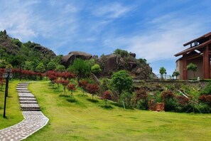 A pathway leading to a building with a garden and red foliage. - Naixing Shihu Leisure Mountain Resort (Chaozhou)