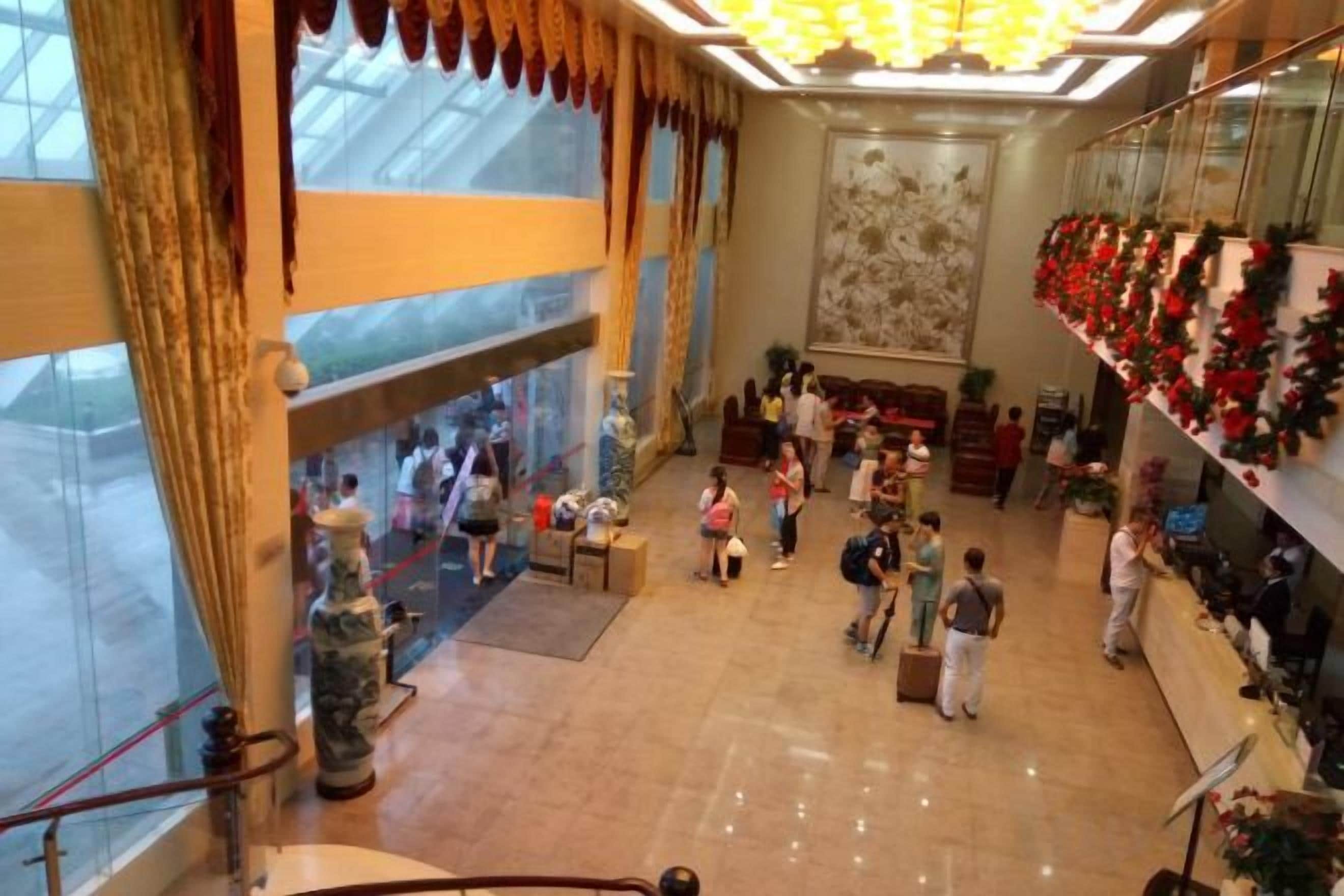 A spacious lobby with a high ceiling, large windows, and a central seating area.