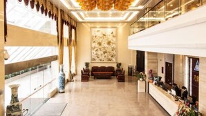 A spacious lobby with a reception desk, seating area, and a large abstract painting on the wall. - Naixing Shihu Leisure Mountain Resort (Chaozhou)