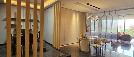 Un interior moderno con comedor, mostrador de recepción y vistas al exterior.