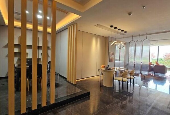 Un interior moderno con comedor, mostrador de recepción y vistas al exterior.