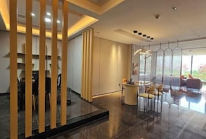 Un interior moderno con comedor, mostrador de recepción y vistas al exterior.