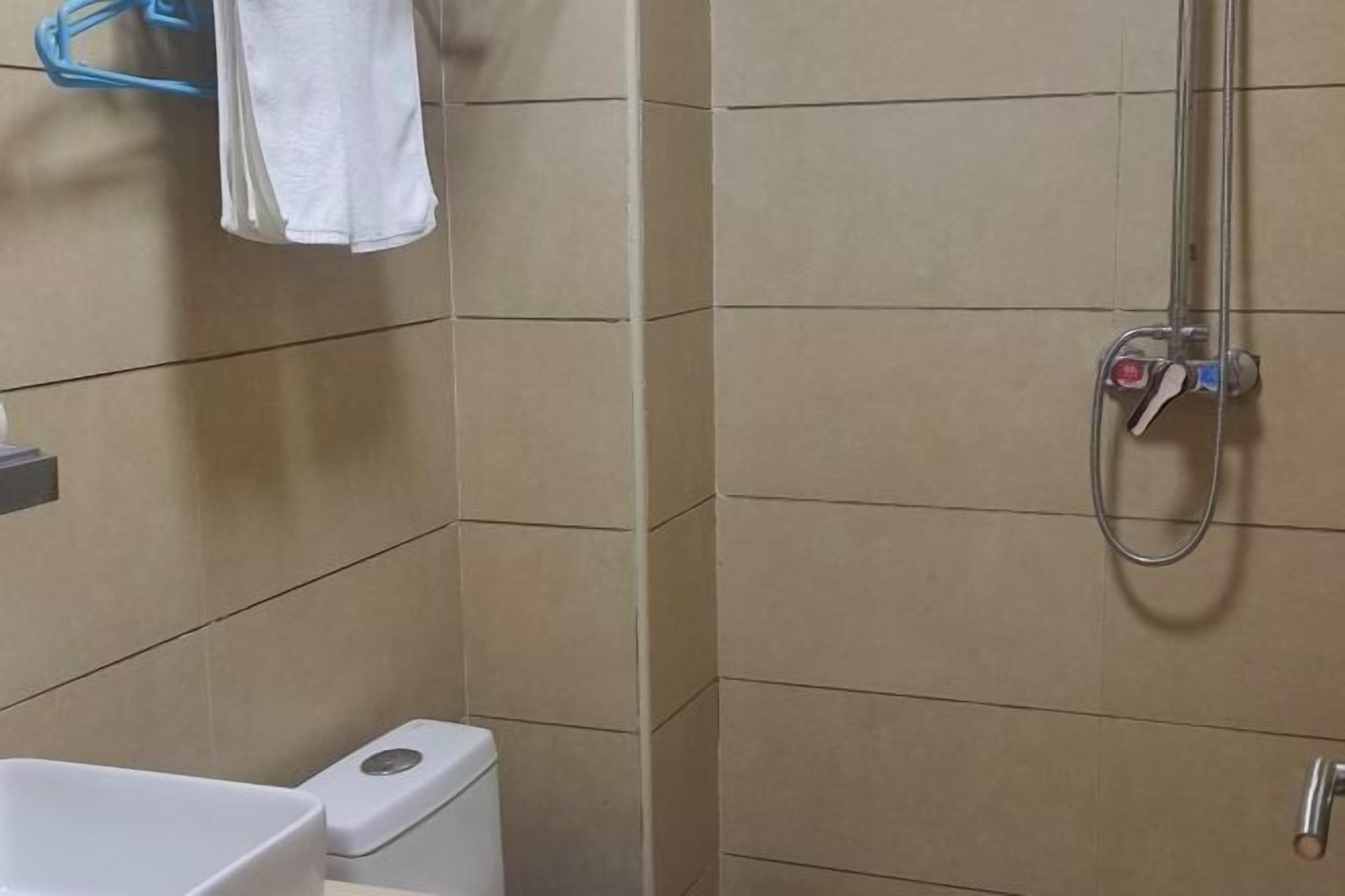 A bathroom with a shower, toilet, and sink.