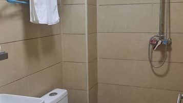 A bathroom with a shower, toilet, and sink.