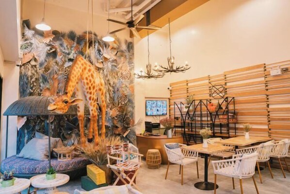 A restaurant with a giraffe mural, wooden slat walls, and a ceiling fan. - B Innspire Hotel (Chiang Mai)