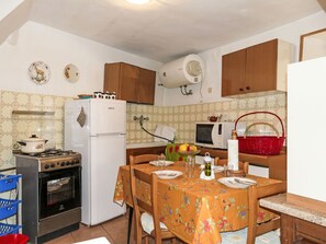 Een koelkast, een microgolfoven, een oven, kookgerei, borden en bestek