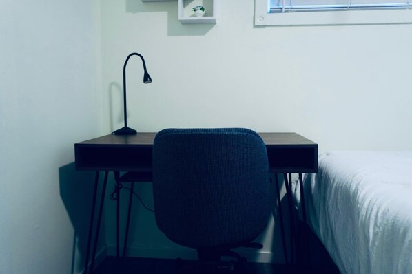 A small, simple room with a desk, chair, and a bed. - Entire suite Neighboring RCMP, Stadium and Airport. (Regina)