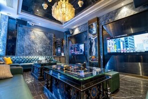 Ein stilvoller Lounge-Bereich mit einer Couch, einer Bar und einem Fernsehbildschirm.