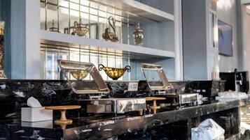 A marble countertop with multiple service stations, a glass display case, and a white shelf with decorative items.