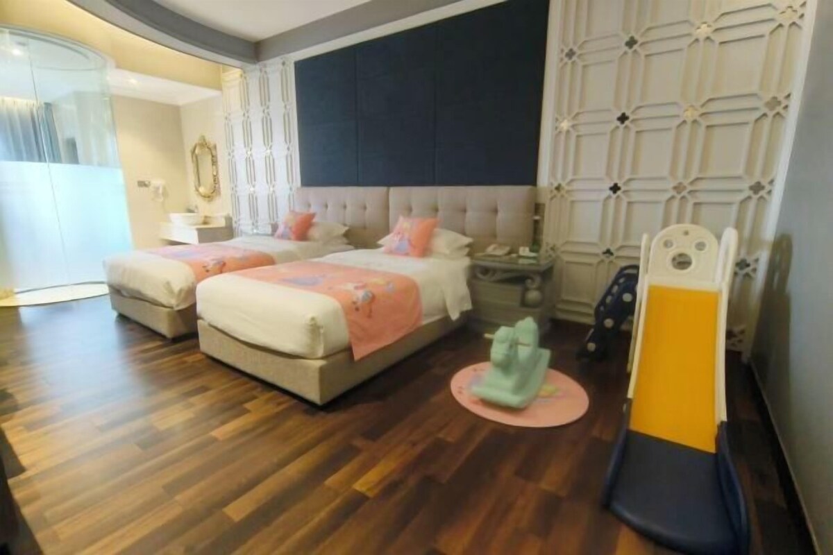 Ein Hotelzimmer mit zwei Betten, einem großen Spiegel, einem Nachttisch und einem kleinen Tisch.
