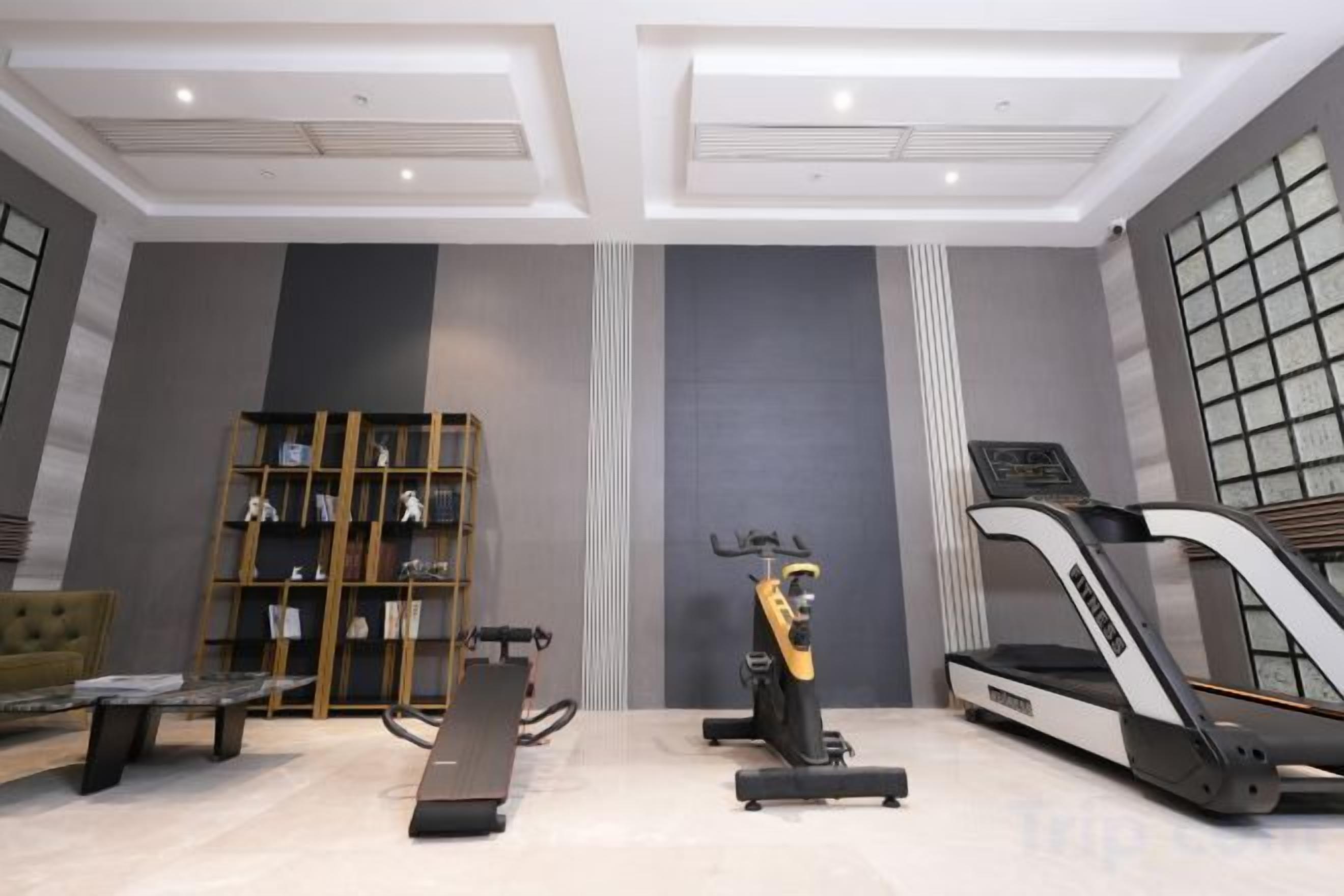 A gym with exercise equipment, a treadmill, and a stationary bike.