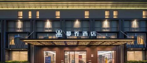 A hotel with a modern facade, multiple floors, and a prominent entrance with a canopy.