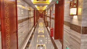 A hotel corridor with marble floors, wooden doors, and recessed lighting. - Yuting Express Hotel (Hai'an)