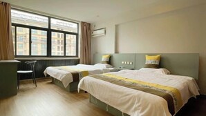 A hotel room with two beds, a desk, and a window with a view of buildings. - Yuting Express Hotel (Hai'an)