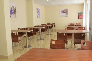 A dining area with multiple tables and chairs, arranged in rows. - Yuting Express Hotel (Hai'an)