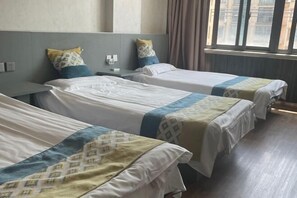 A hotel room with two single beds, a nightstand, a window with curtains, and a view of buildings outside. - Yuting Express Hotel (Hai'an)