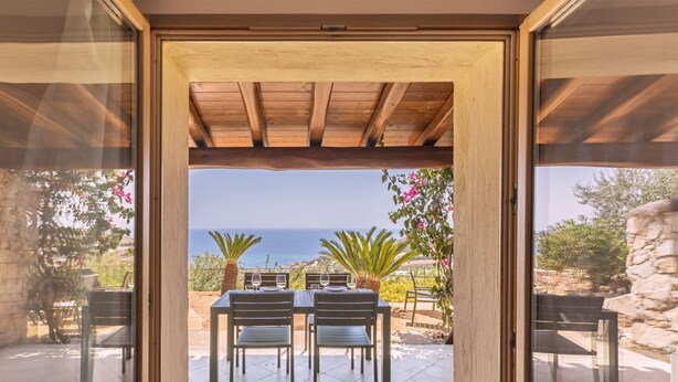 A patio with a table and chairs, overlooking a scenic view of the sea. - Casa Lulù with seaview and shared pool (Tertenia)