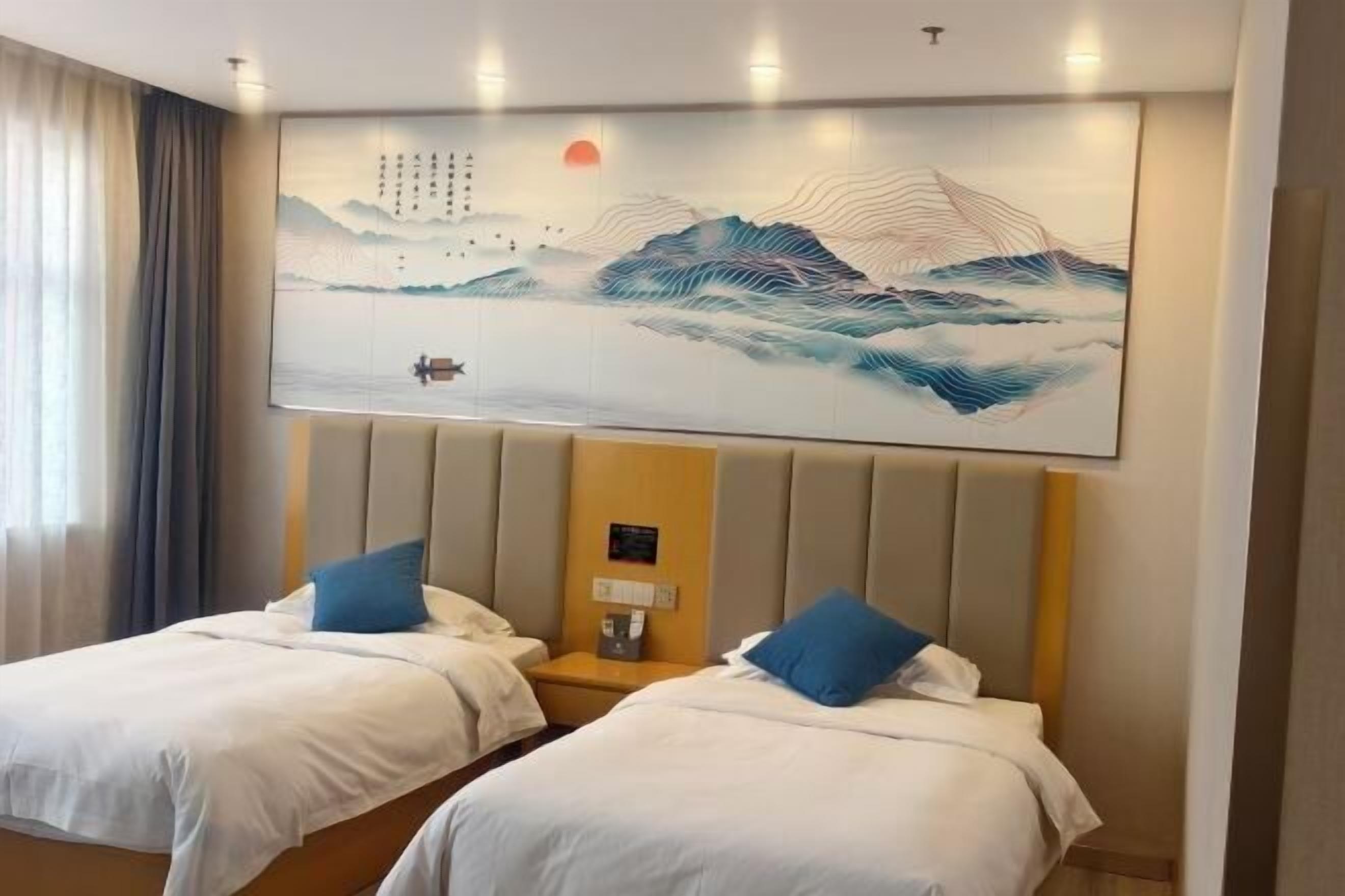 Una habitación de hotel con dos camas, una obra de arte grande en la pared y una mesita de noche con lámpara.