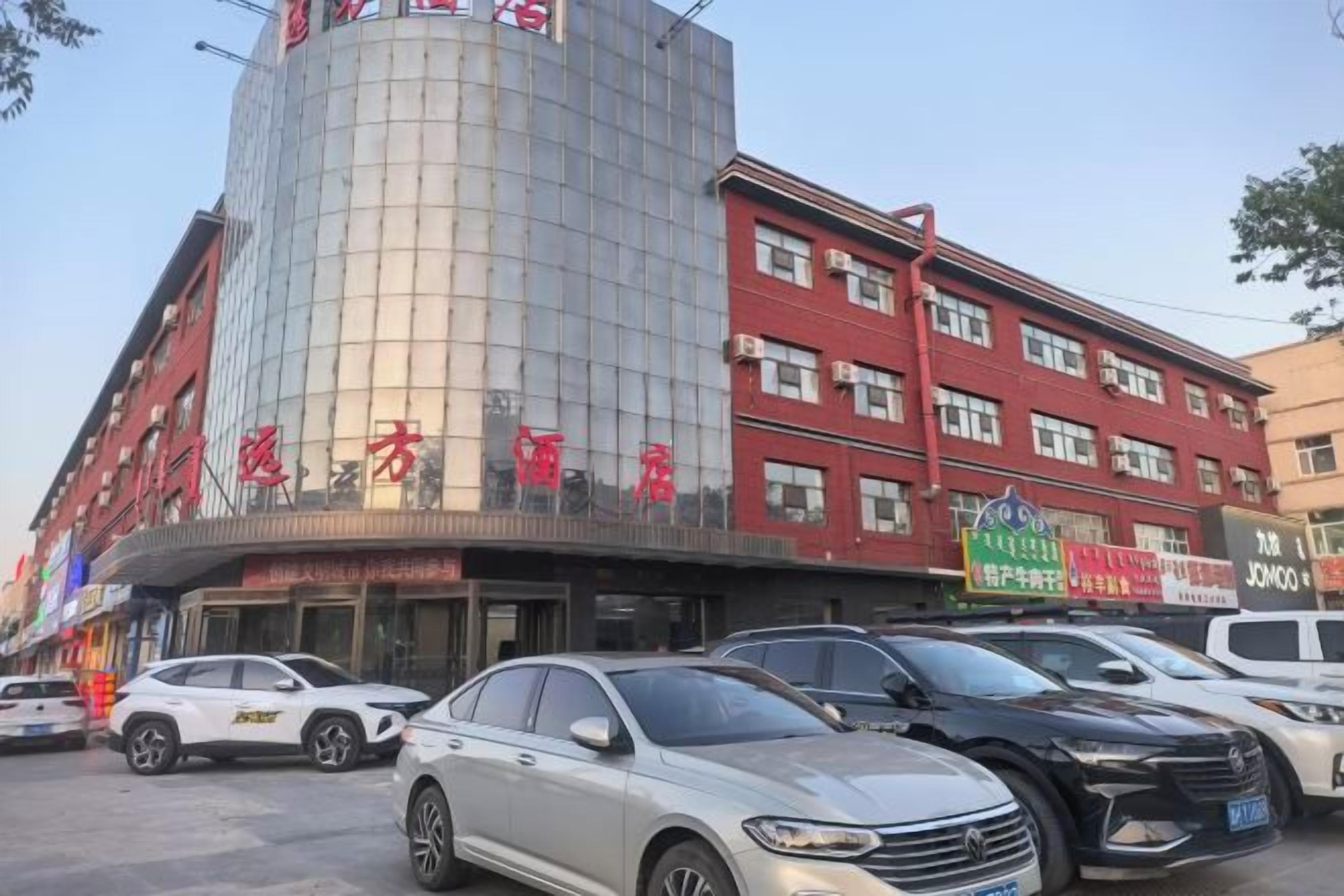 A multi-story hotel with a curved facade, multiple floors, and a variety of signage.