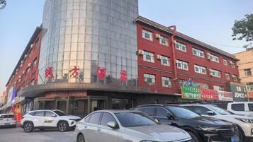 A multi-story hotel with a curved facade, multiple floors, and a variety of signage.
