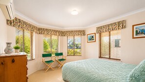 A bedroom with a bed, two chairs, a dresser, and windows with blinds. - Hidden Gem Getaway in Dunsboroughs Heart (Dunsborough)