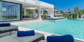 A modern pool area with lounge chairs and a sun terrace. - Villa Hanami, Luxury Pearl in Marbella (Estepona)