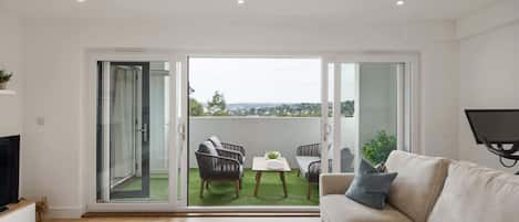 A modern living room with a sofa, a small round table, and a TV.