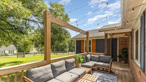 An outdoor patio with a wooden pergola, a sectional sofa, and a coffee table. - Relaxing Belmont Escape, 4BR, Pet Friendly (Belmont)