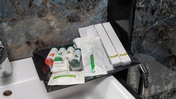 Et badeværelsesstel med toiletartikler og en badehætte på en bakke.
