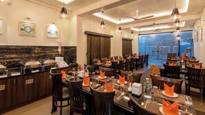 A restaurant with multiple dining tables, chairs, and a buffet area. - Hotel Altitude Coorg (Madikeri)