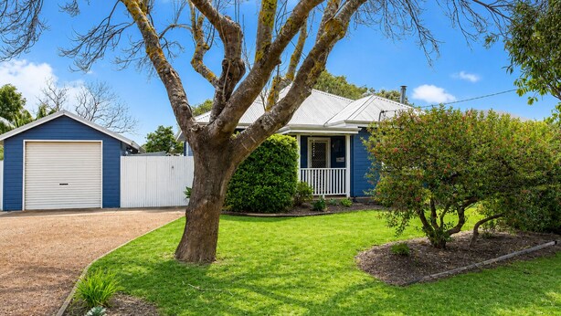A residential property with a garage, a house with a porch, and a well-maintained lawn. - Relax and Unwind at Otters Retreat (West Busselton)