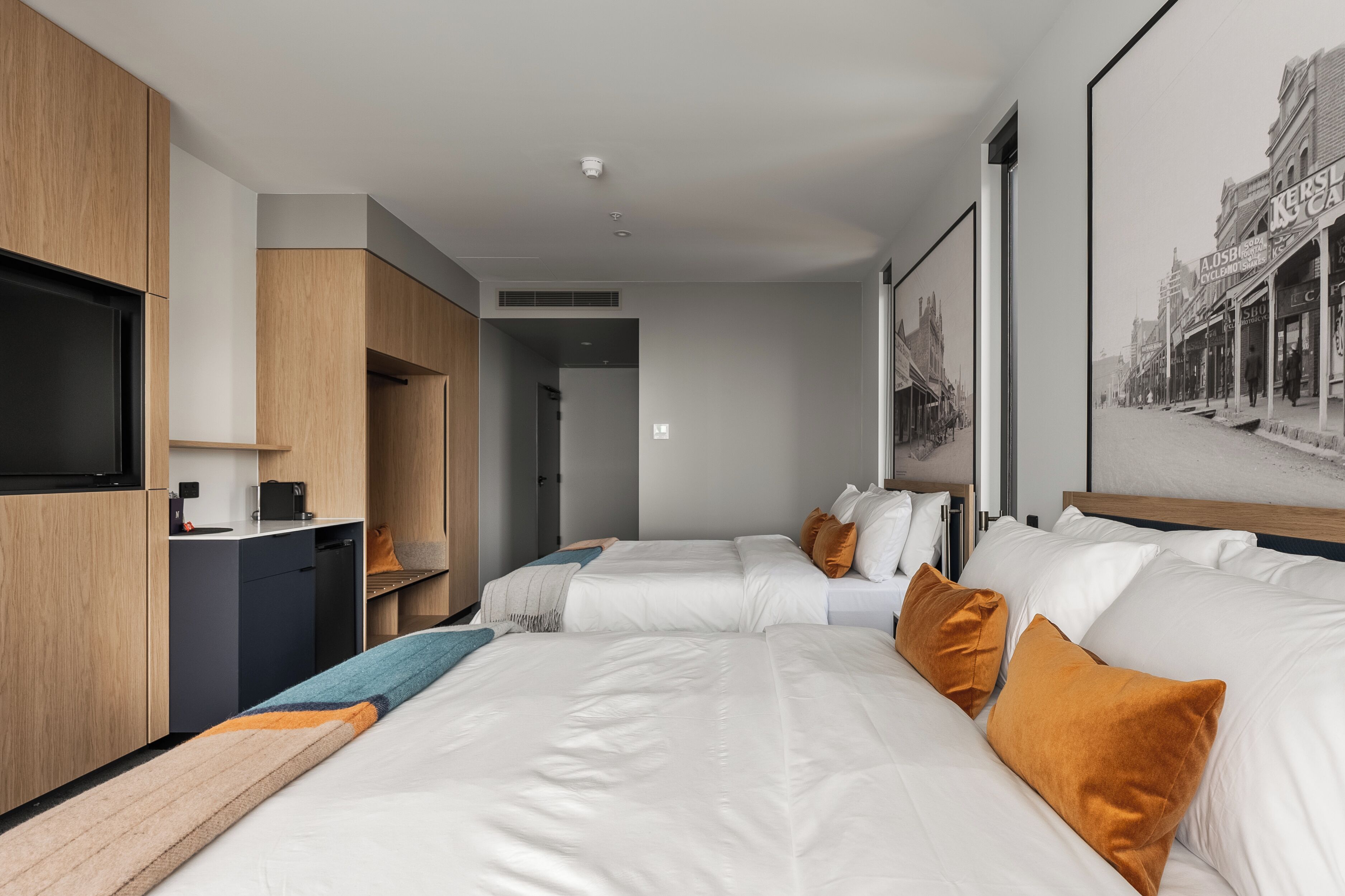 A modern hotel room with a large bed, a desk, and a flat-screen TV.