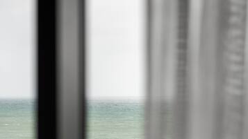A view through a window with a blurred background, likely an ocean or sea.
