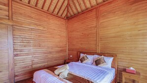 A wooden room with a bed, wooden walls, and a sloped ceiling. - D Sila’s Tepi Danu Villas Kintamani & Natural hot spring (Kintamani)