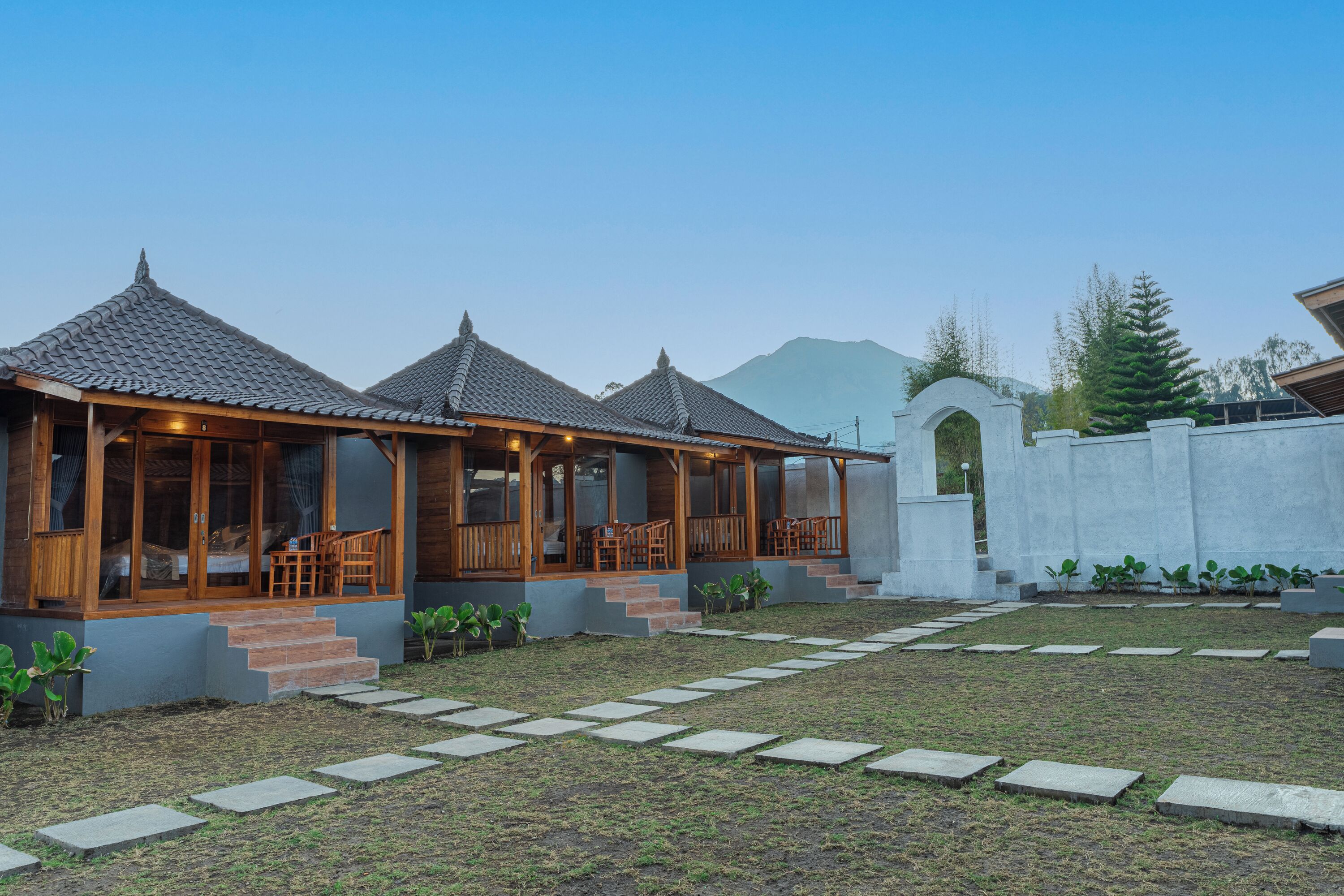 A traditional-style building with a covered patio area, stone steps, and a garden pathway.