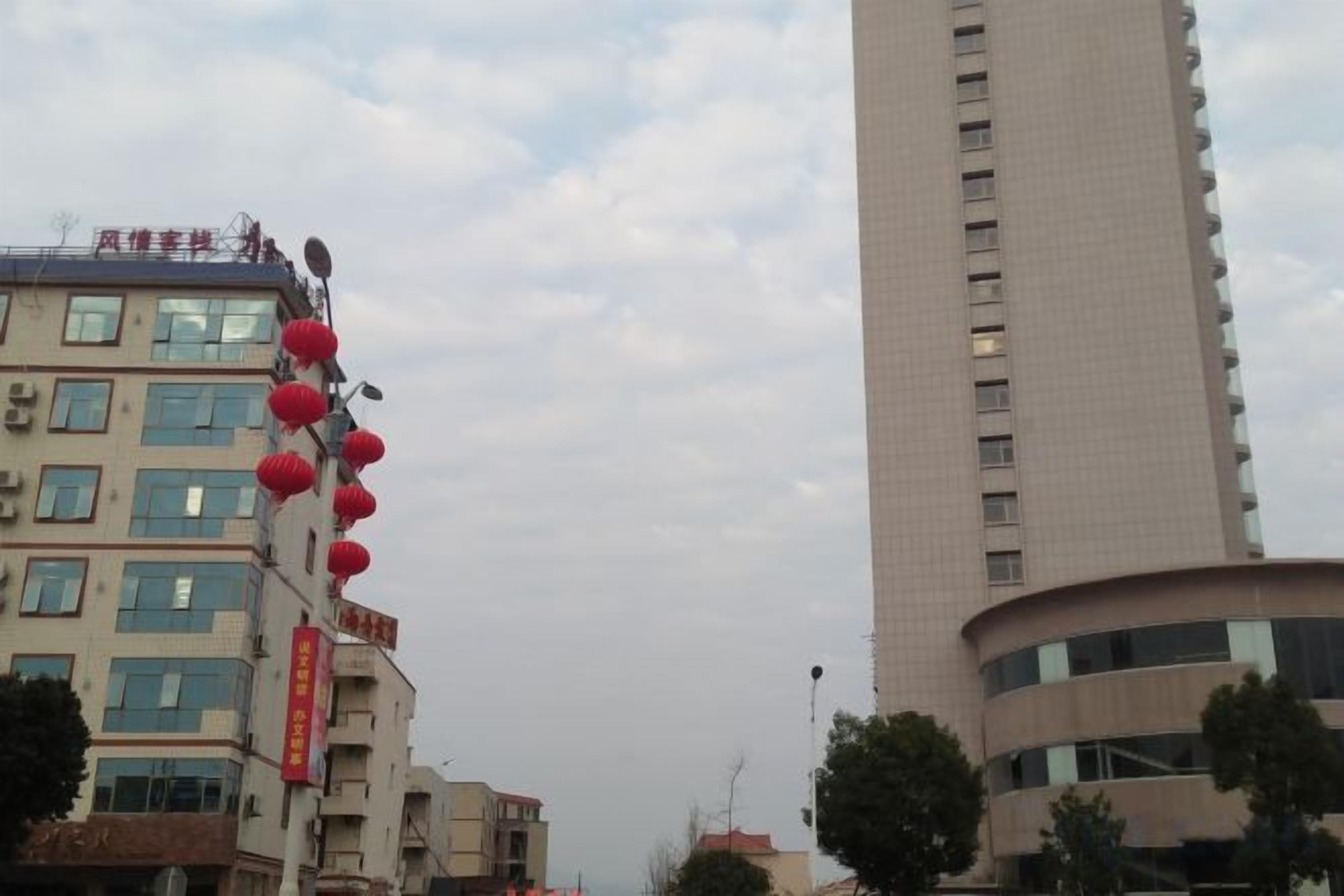A tall building with multiple windows and a curved corner.