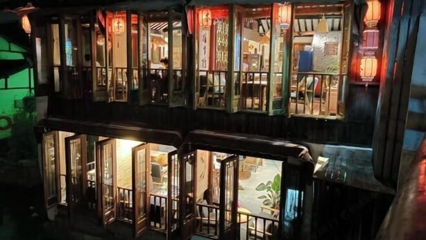 Un edificio tradicional con varias ventanas y puertas abiertas, que dejan entrar la luz natural.