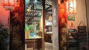 Un interior tradicional con puertas de madera, faroles colgantes y un escaparate visible que muestra diversos artículos.