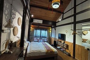 A hotel room with a bed, wooden ceiling, a TV, and a window with a view. - Xiehou No.92 Inn (Shanghai)