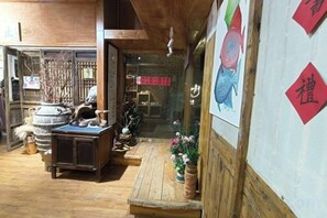 A traditional interior with wooden flooring, a stone fireplace, and a small wooden table. - Xiehou No.92 Inn (Shanghai)