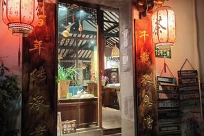 A traditional Chinese shop entrance with wooden doors and hanging lanterns. - Xiehou No.92 Inn (Shanghai)
