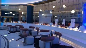 A modern lobby with seating areas, a reception desk, and decorative elements. - Vest Holiday Hotel (Urumqi)